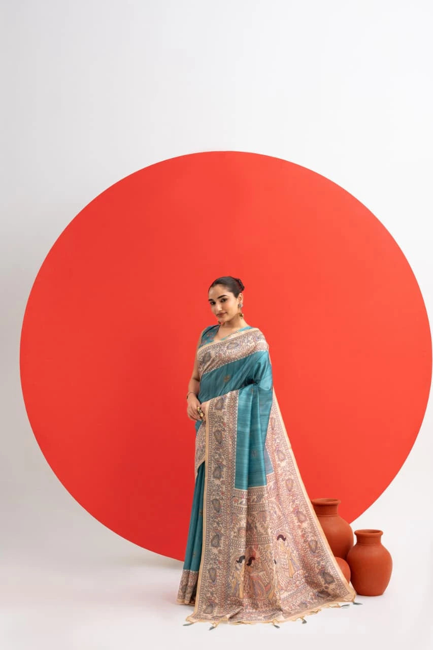 Woman in a blue and beige saree standing against a white background with a large red circle.