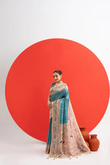 Woman in a blue and beige saree standing against a white background with a large red circle.