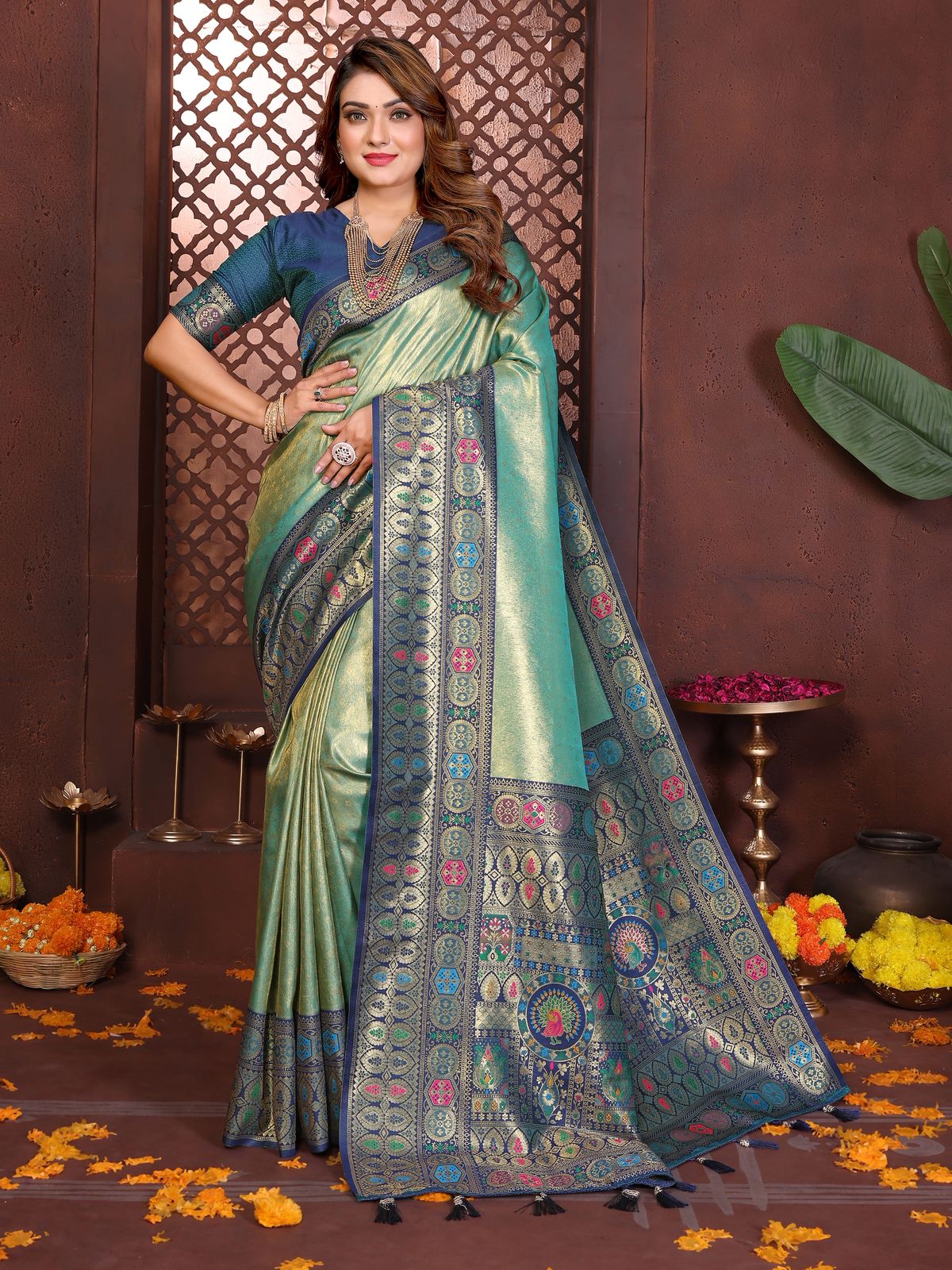 Woman wearing a traditional saree with intricate patterns in a decorative setting.