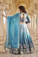 Woman in a traditional blue and white embroidered outfit standing in an ornate architectural setting.