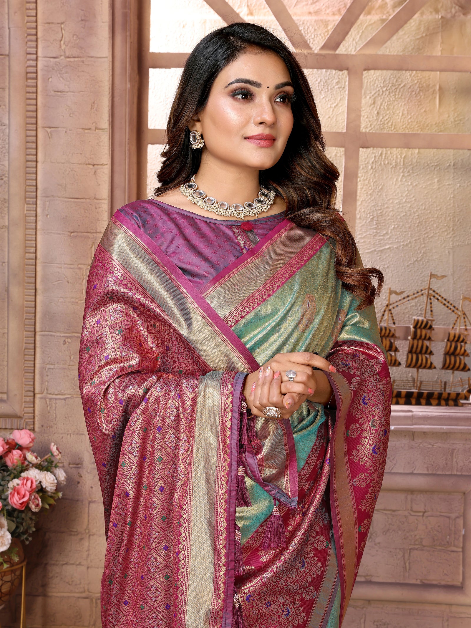 Woman wearing a traditional saree with a decorative background