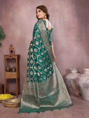 Woman wearing a green saree with a geometric pattern in an indoor setting.