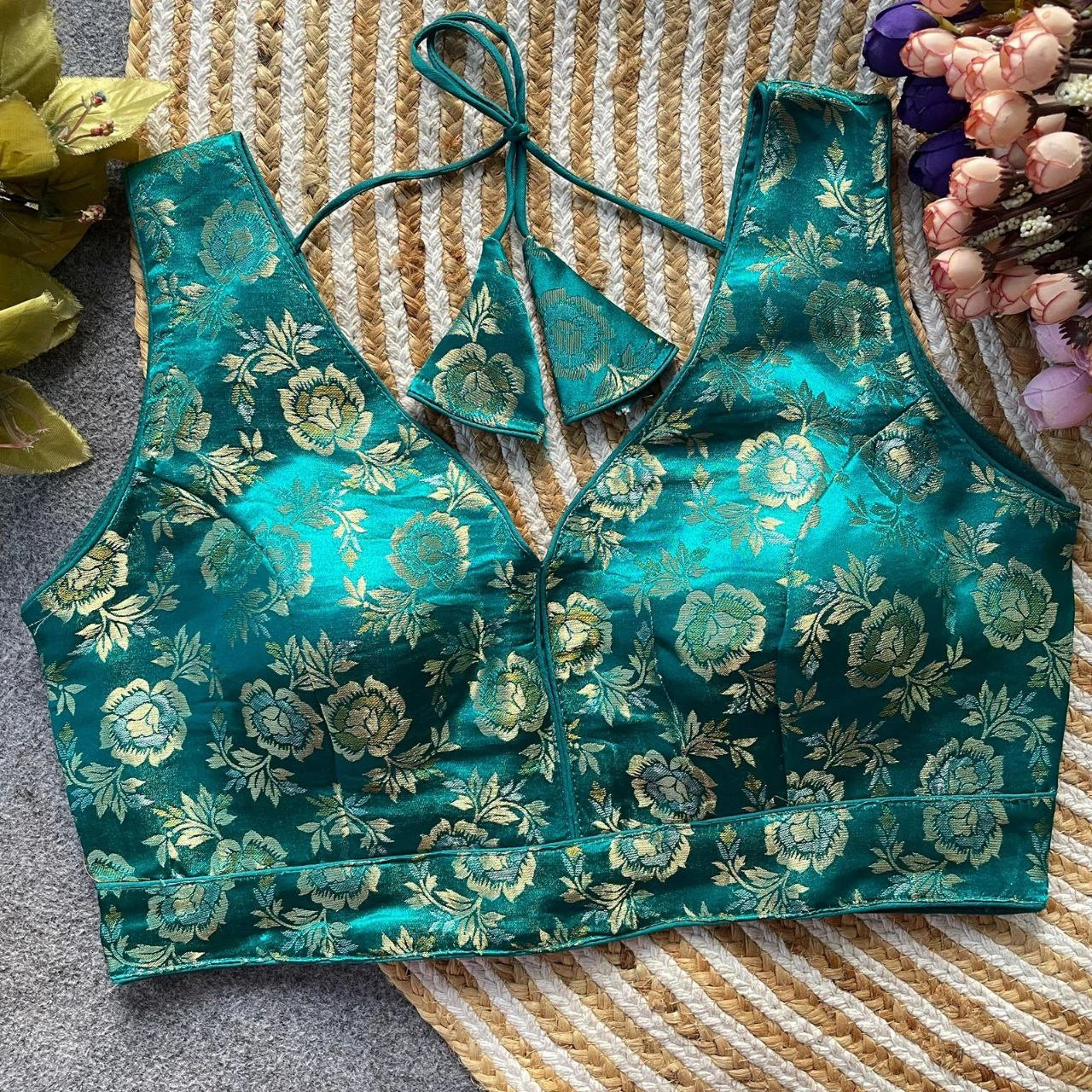 Teal floral patterned top on a textured surface