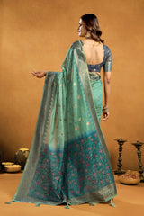 Woman wearing a green saree with a brown background