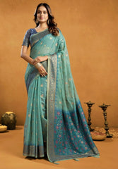 Woman wearing a teal saree with a brown background