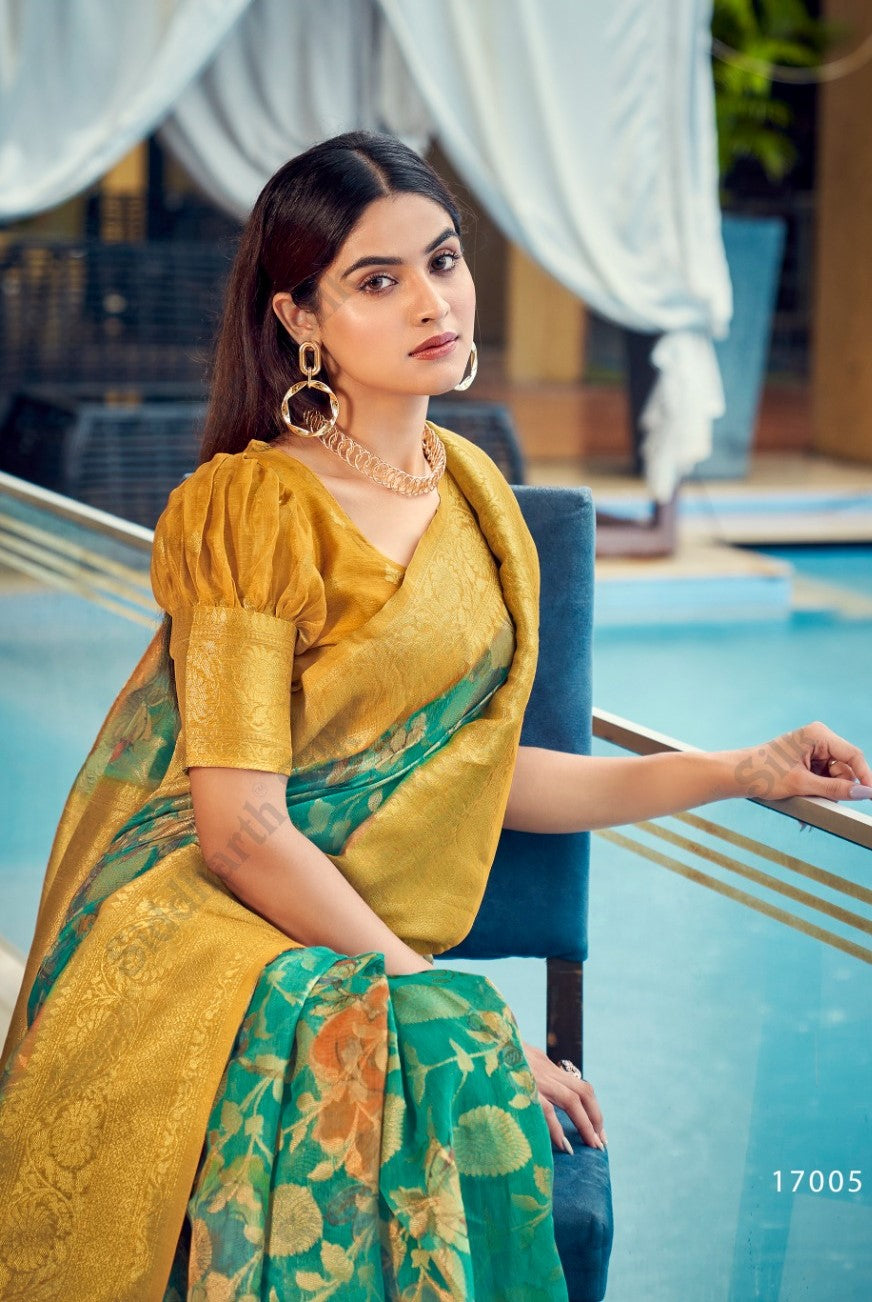 Woman in a tropical green zari work saree with floral patterns and golden pallu, styled elegantly with statement jewelry by the poolside