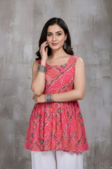 Woman wearing a red patterned top against a gray background