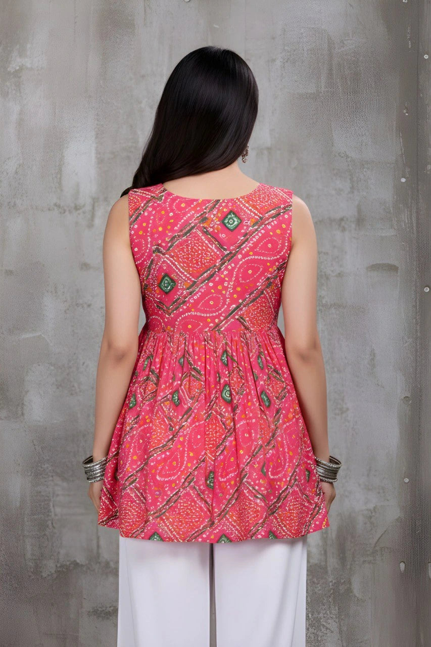 Woman wearing a red patterned top against a gray concrete wall