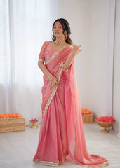 Woman wearing a pink saree with gold border in a minimalistic setting