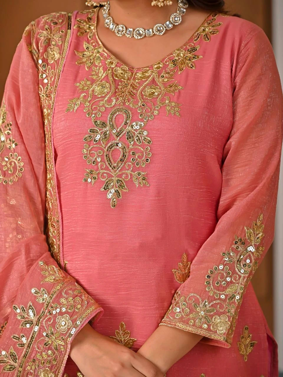 Pink traditional outfit with gold embroidery and jewelry