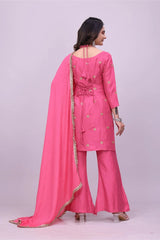 Woman wearing a pink traditional outfit with a matching dupatta on a light purple background
