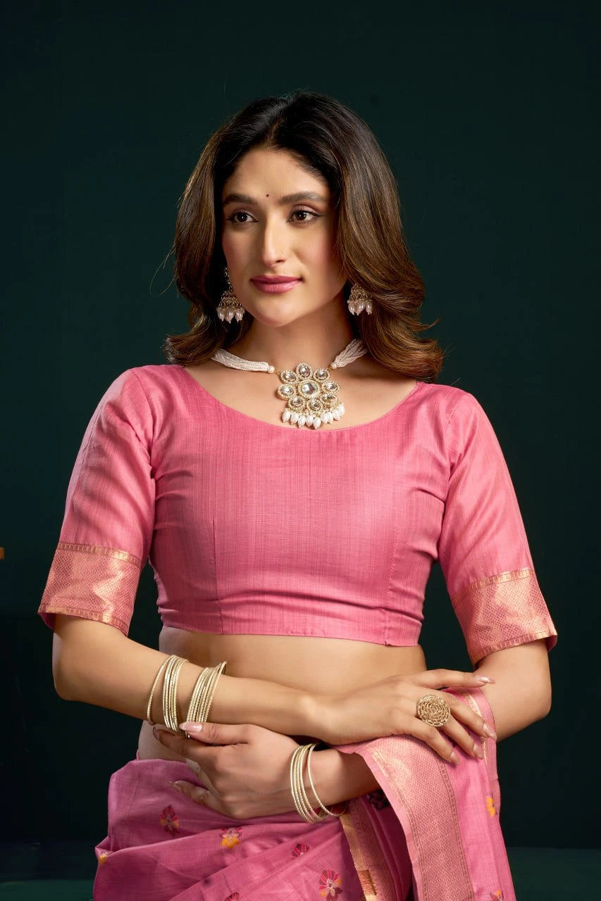Woman wearing a pink saree with a dark background