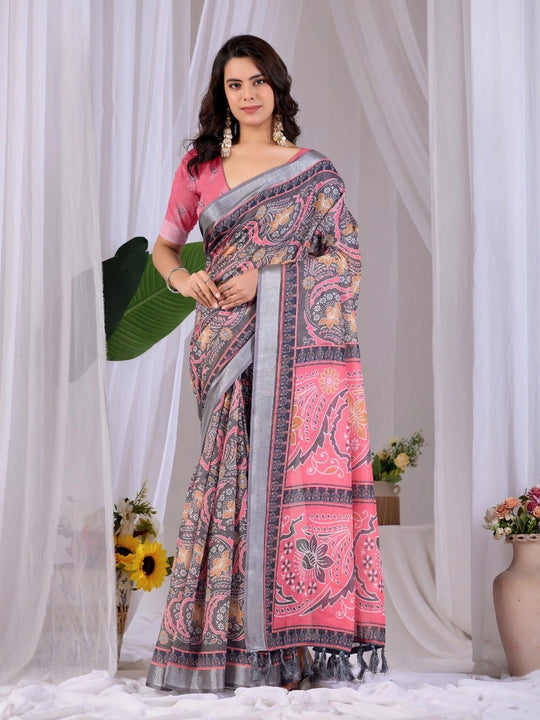 Woman wearing a pink and gray saree with a white curtain background