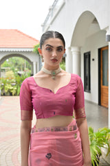 Woman in a pink traditional outfit standing outdoors.