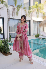 Woman in a pink traditional outfit standing by a poolside.