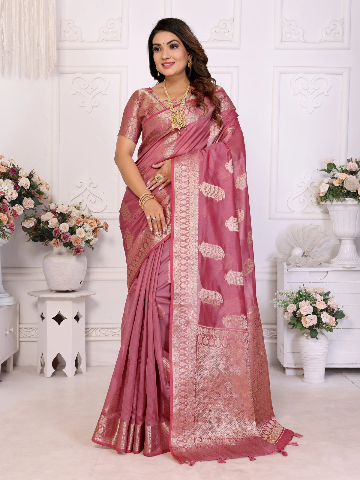 Woman wearing a pink saree with a white background