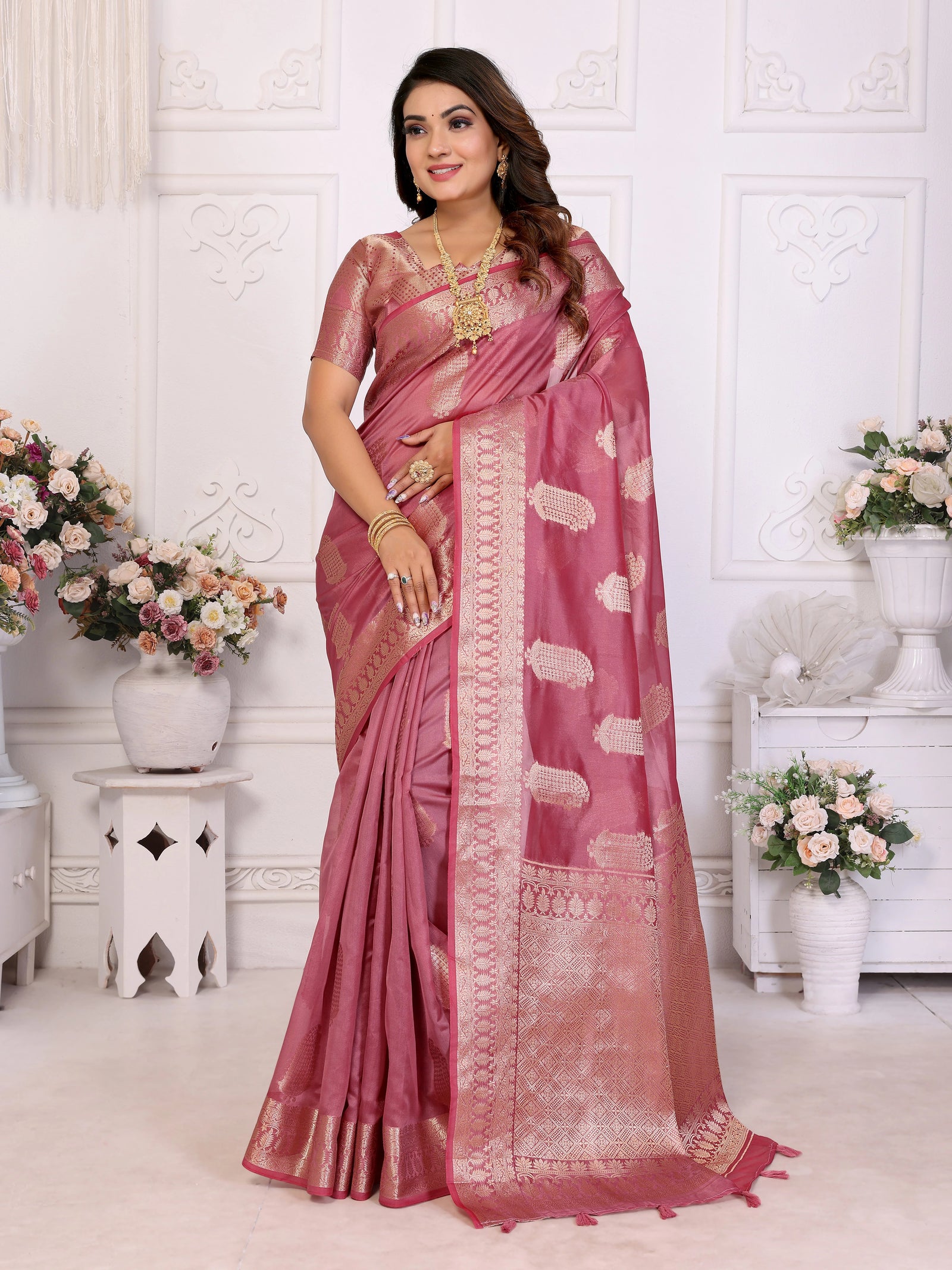 Woman wearing a pink saree with a white background