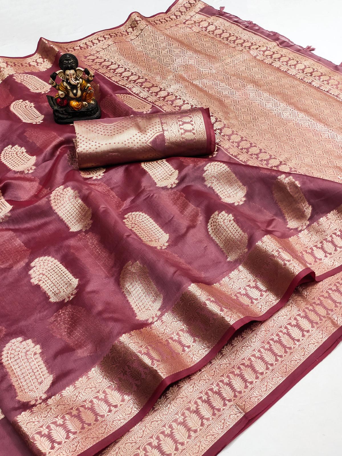Maroon and beige saree with a decorative item on a white background