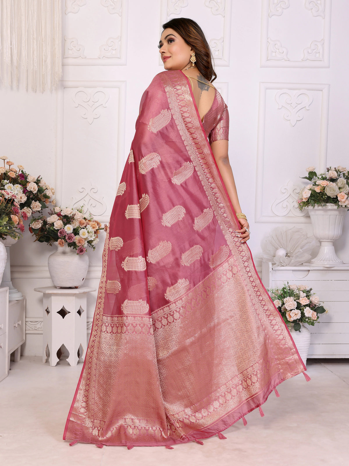 Woman wearing a pink saree with a white background