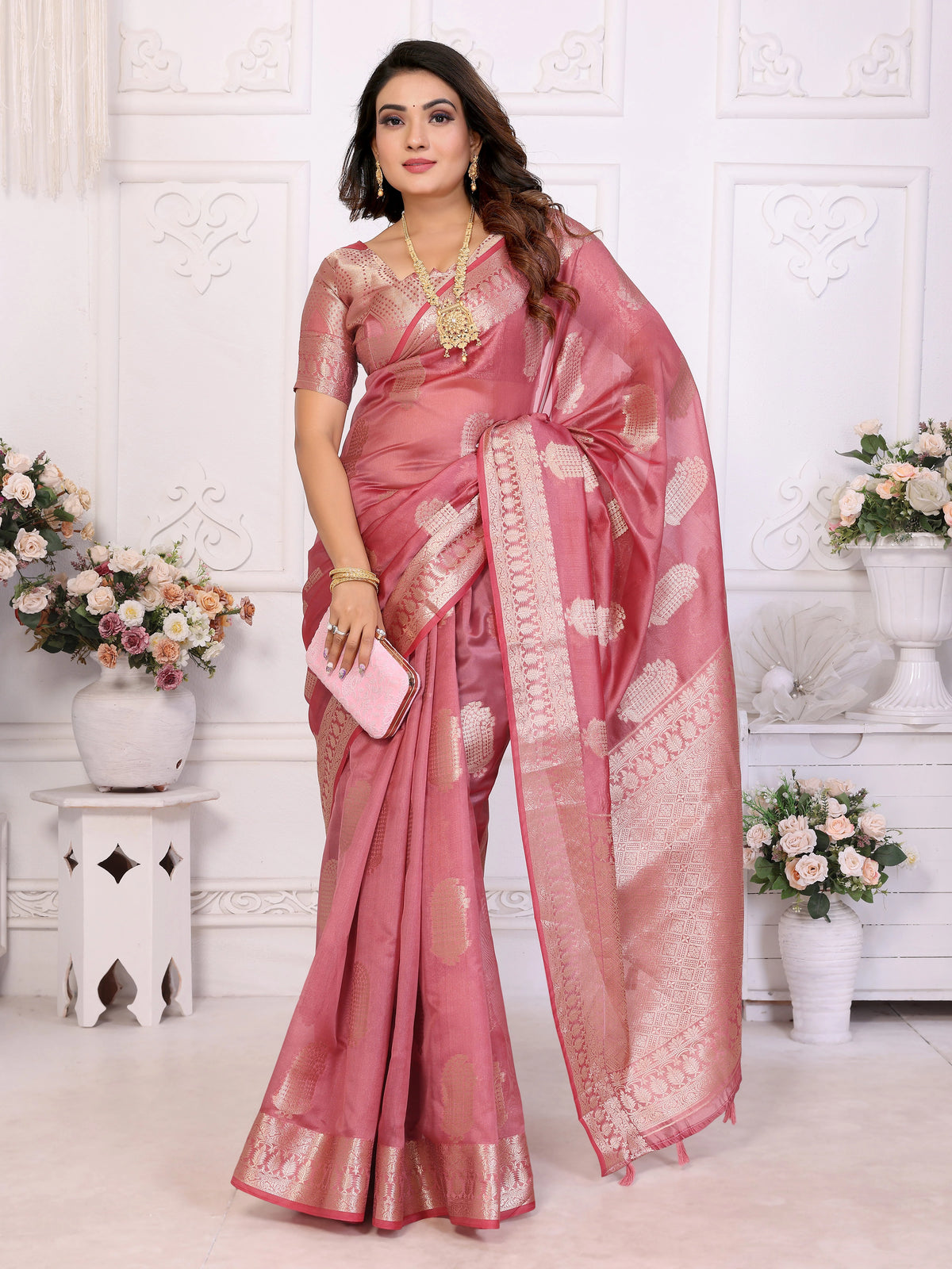 Woman wearing a pink saree with a white background