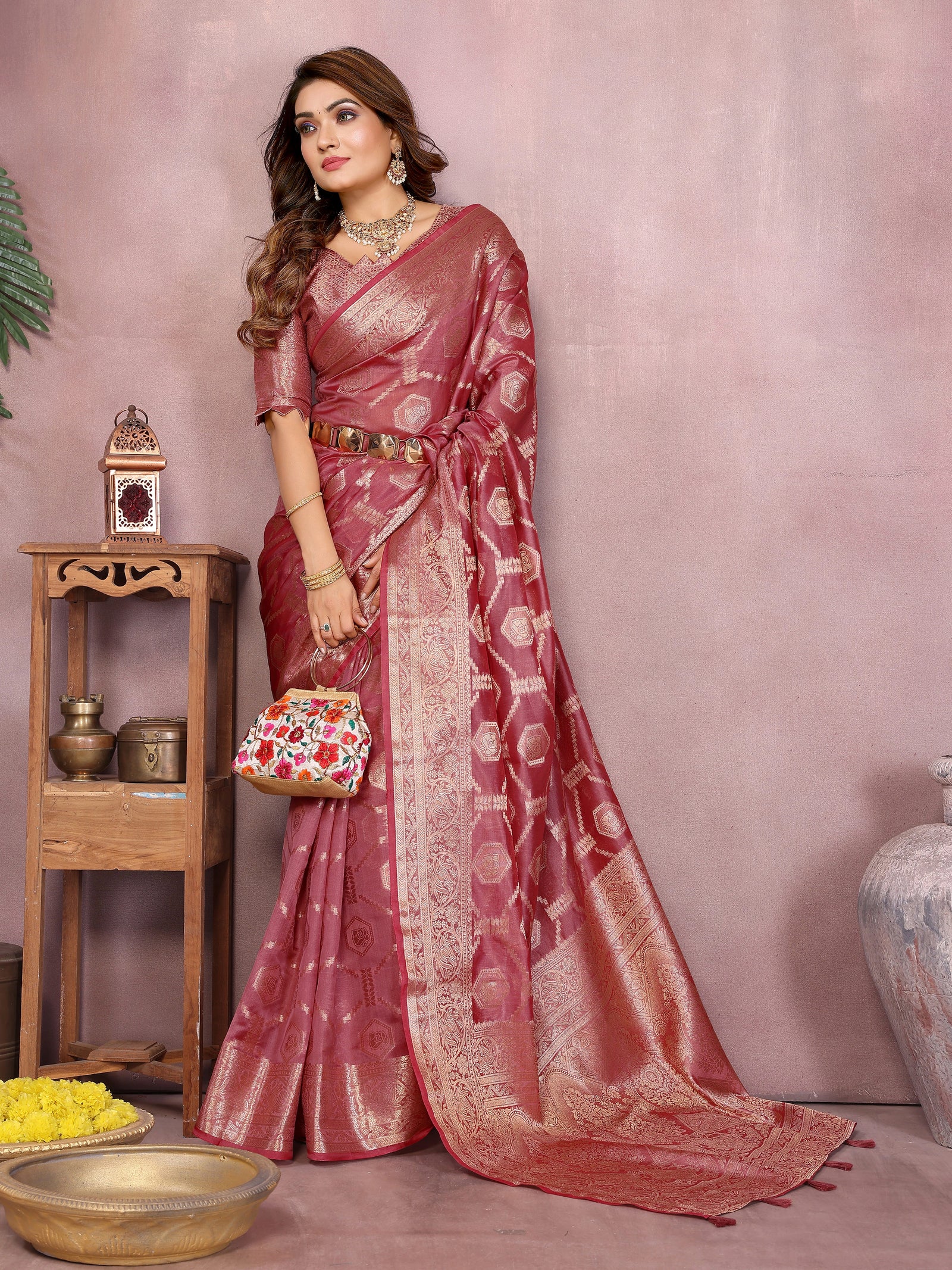 Woman in a pink saree with a decorative background