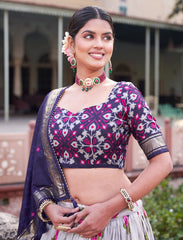 Woman wearing a traditional outfit with a purple and pink blouse in an outdoor setting