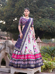 Woman in a traditional outfit with a floral design standing outdoors.