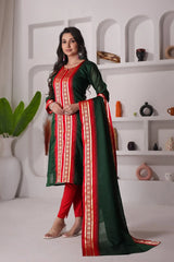 Woman wearing a green and red traditional outfit in a minimalistic room.