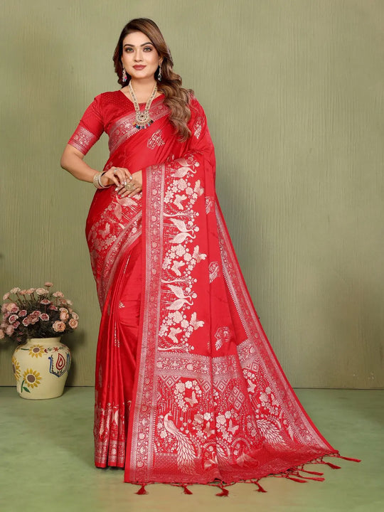 Woman wearing a red saree with white patterns on a green background