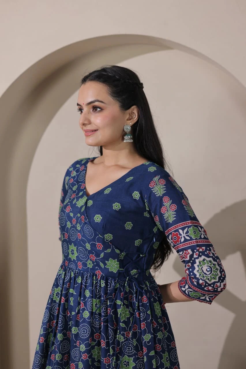 Woman wearing a blue floral dress standing in front of an archway.