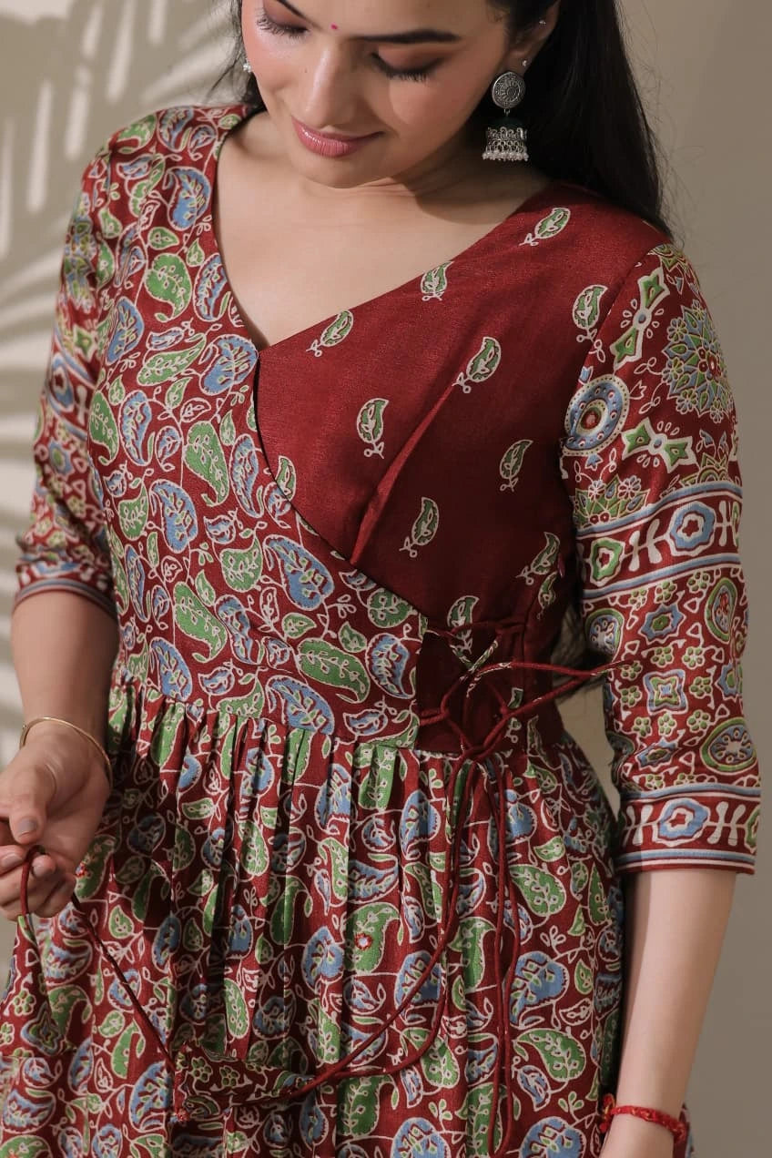 Woman wearing a red patterned dress with a neutral background