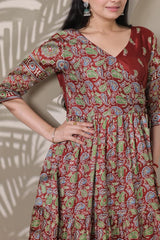 Woman wearing a red patterned dress with a neutral background
