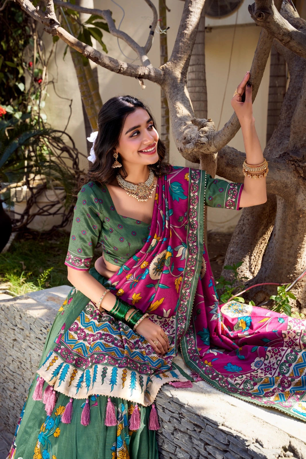 Woman in traditional outfit sitting under a tree