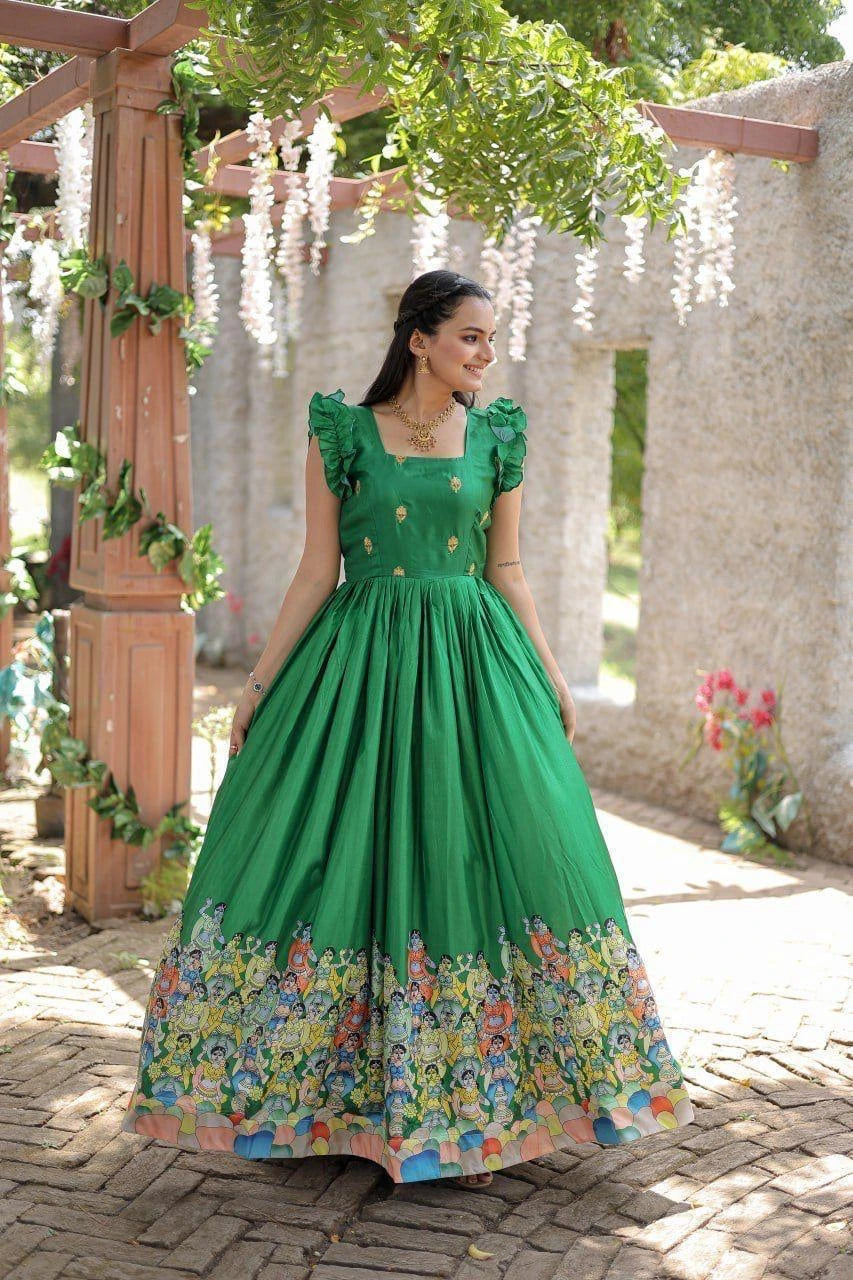 Woman in a green dress with floral pattern standing outdoors.