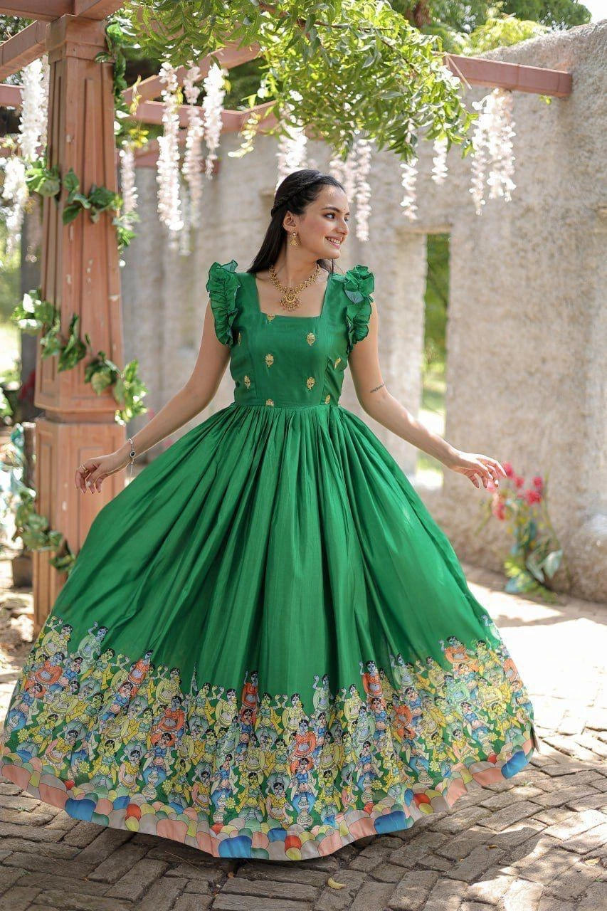Woman in a green dress with floral skirt standing outdoors.