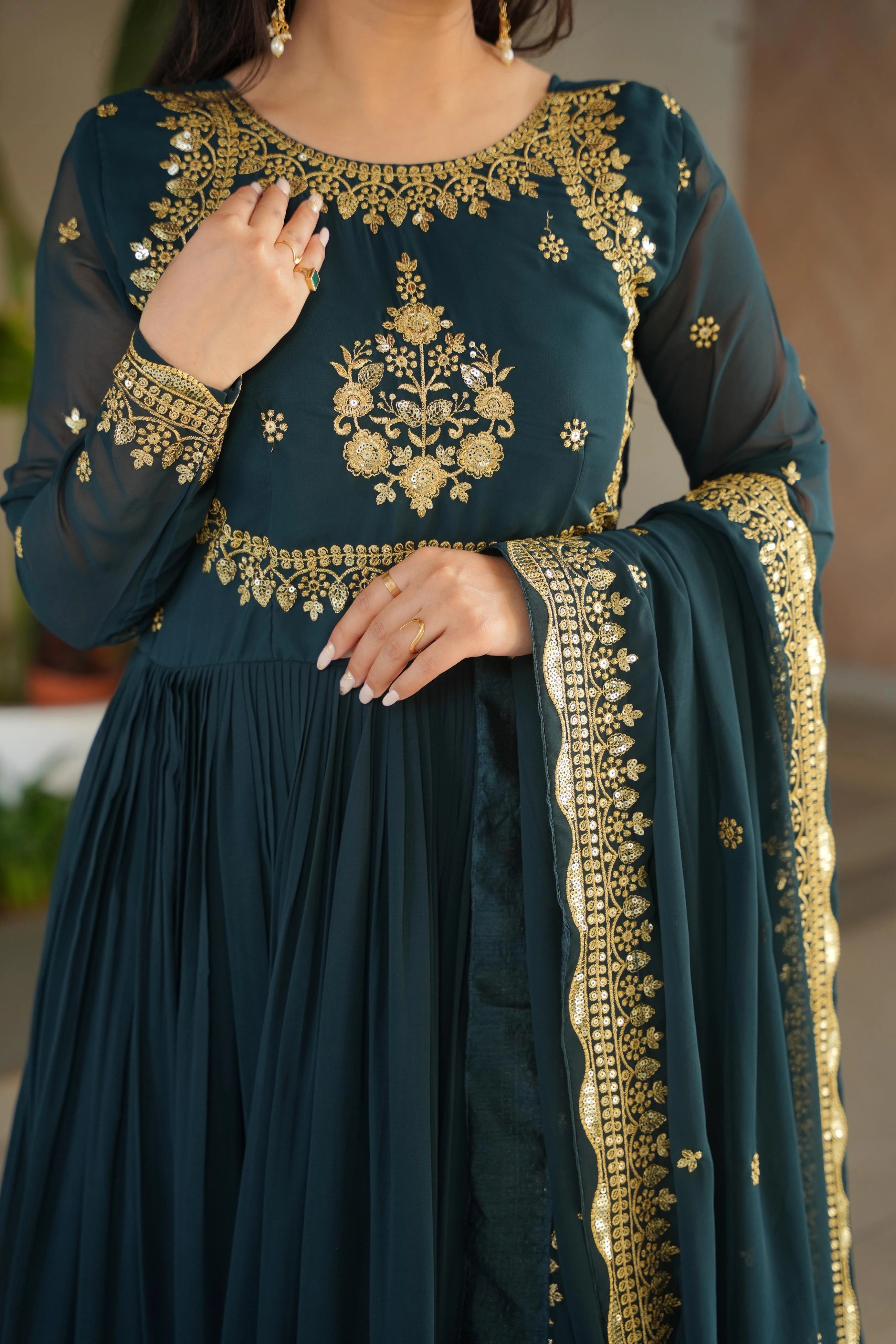 Teal outfit with gold embroidery on a blurred background
