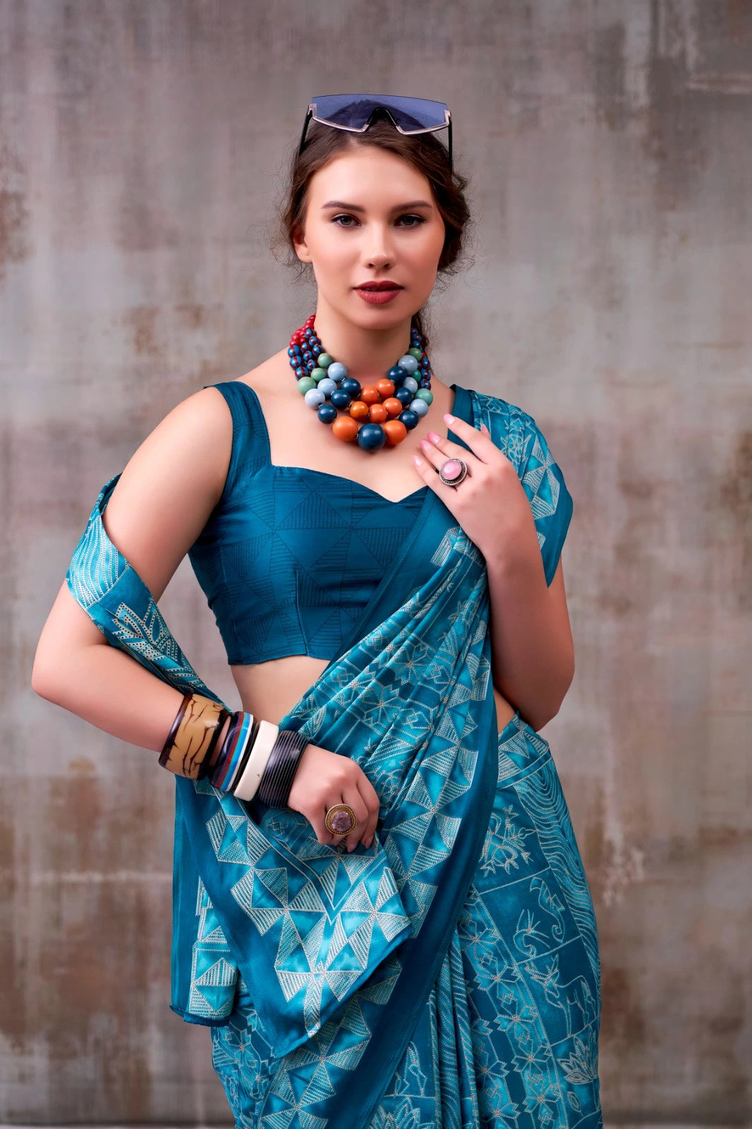 Woman wearing a blue saree with a textured background