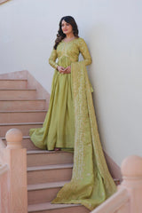 Woman in a green traditional outfit standing on a staircase.
