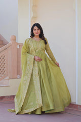 Woman wearing a green traditional outfit with embroidery in an indoor setting.
