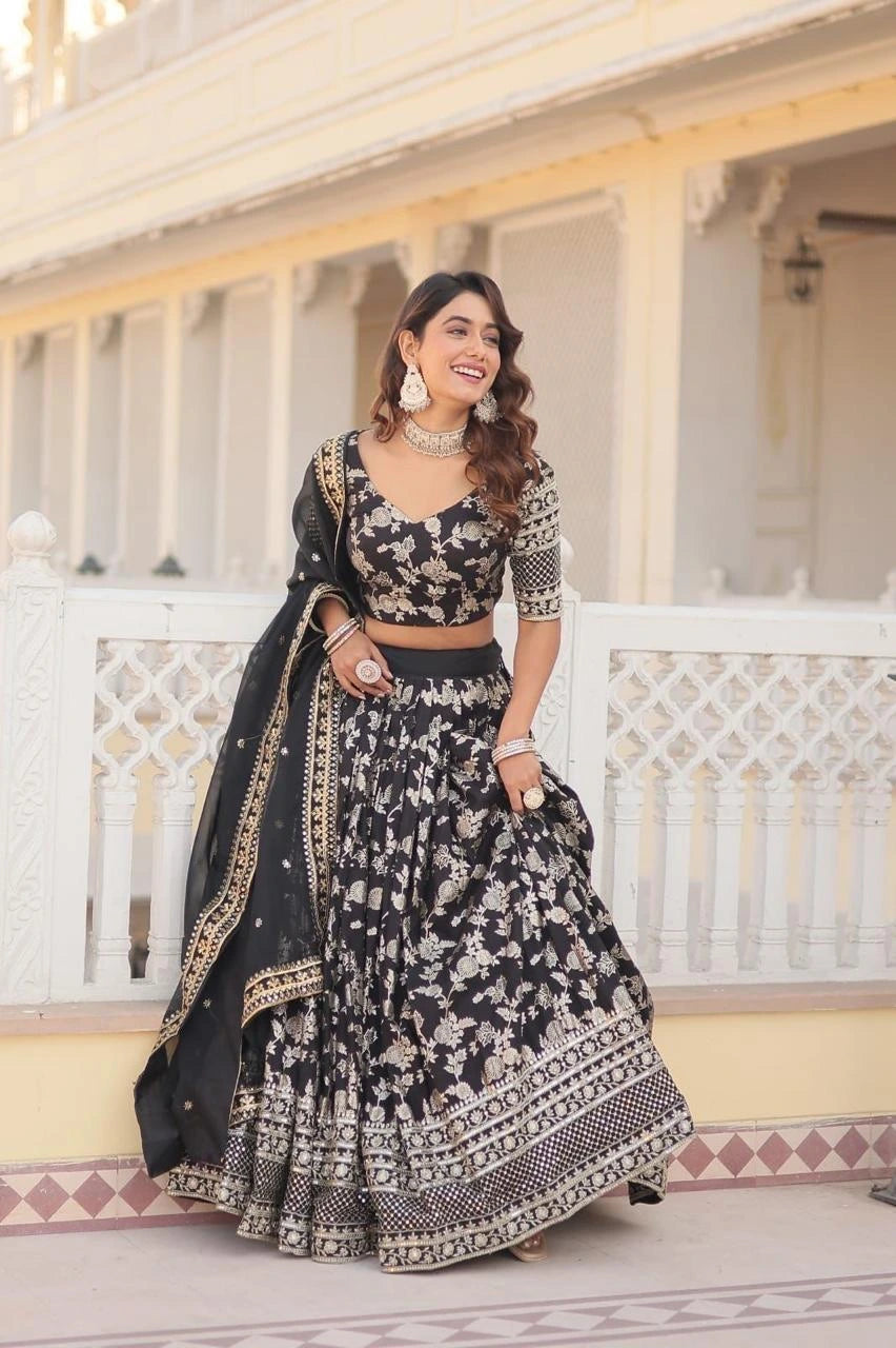Woman in a black and white patterned traditional outfit standing on a balcony.