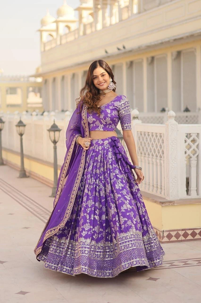 Woman in a purple traditional outfit standing in front of a building with white railings.