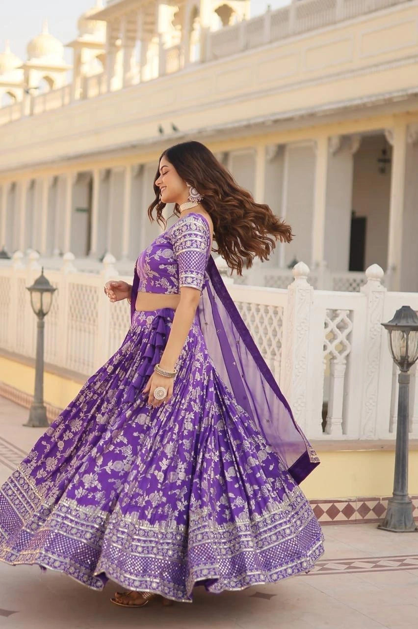 Woman in a purple traditional outfit standing in front of a white building with columns.