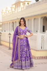 Woman in a purple traditional outfit standing in front of a building with columns.
