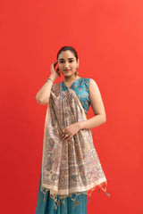 Woman wearing a blue traditional outfit with a patterned dupatta against a red background