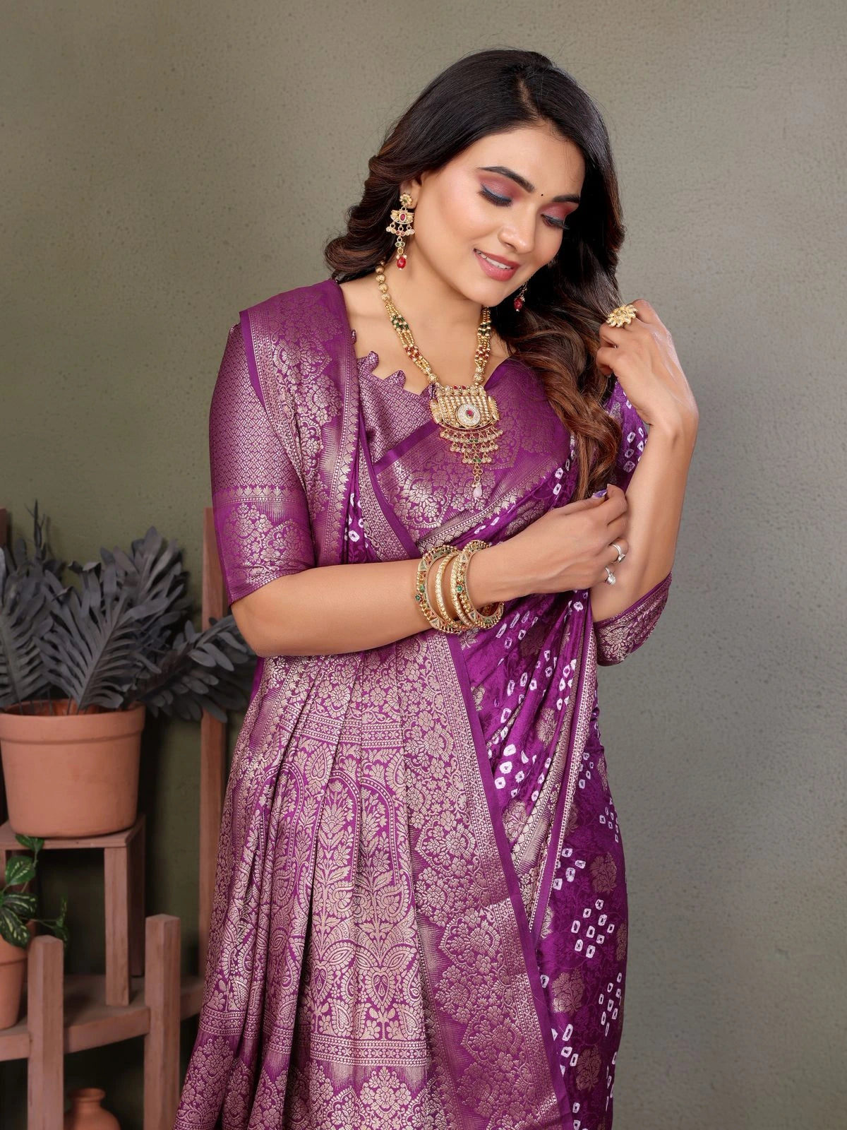 Woman wearing a purple saree with a gray background