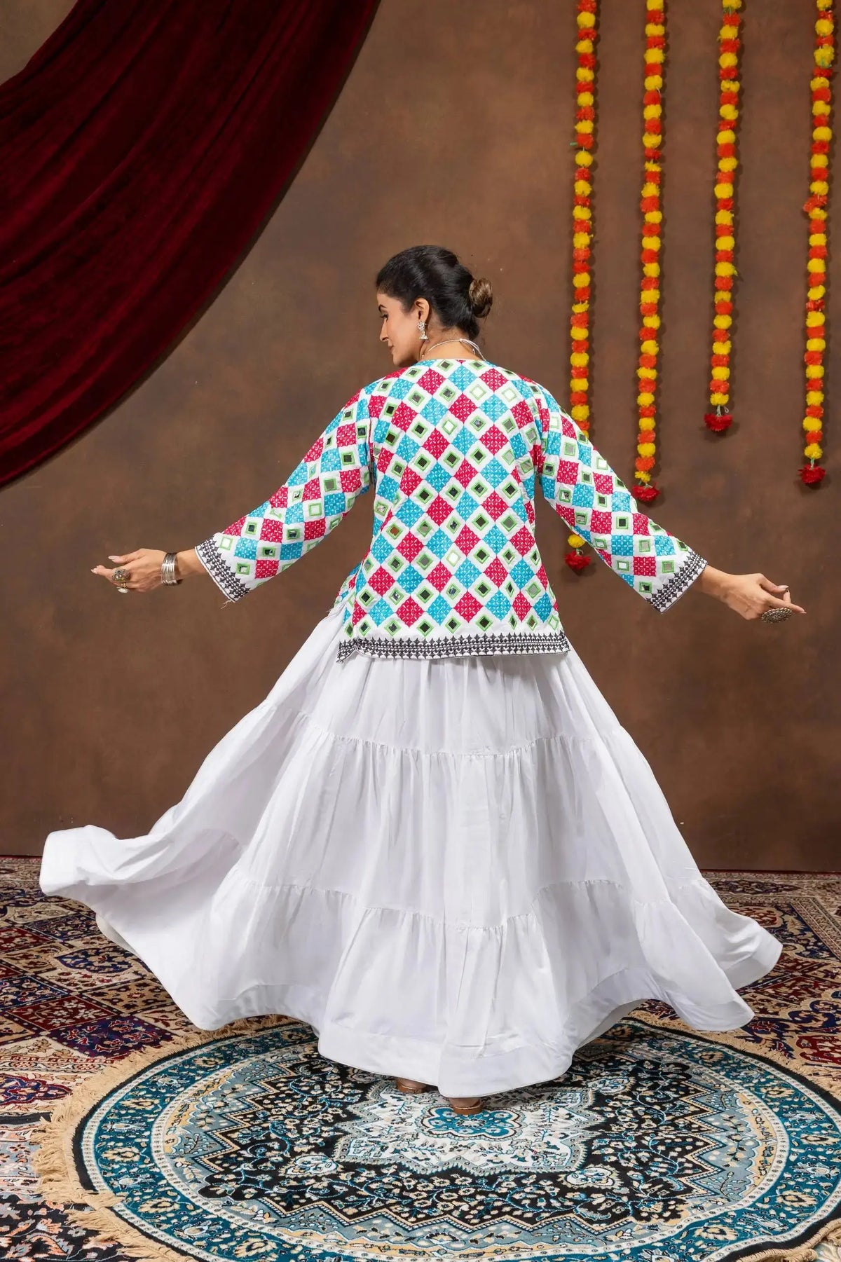 Back twirling view of white 6-meter tiered pure rayon lehenga with multicolor bandhej jacket