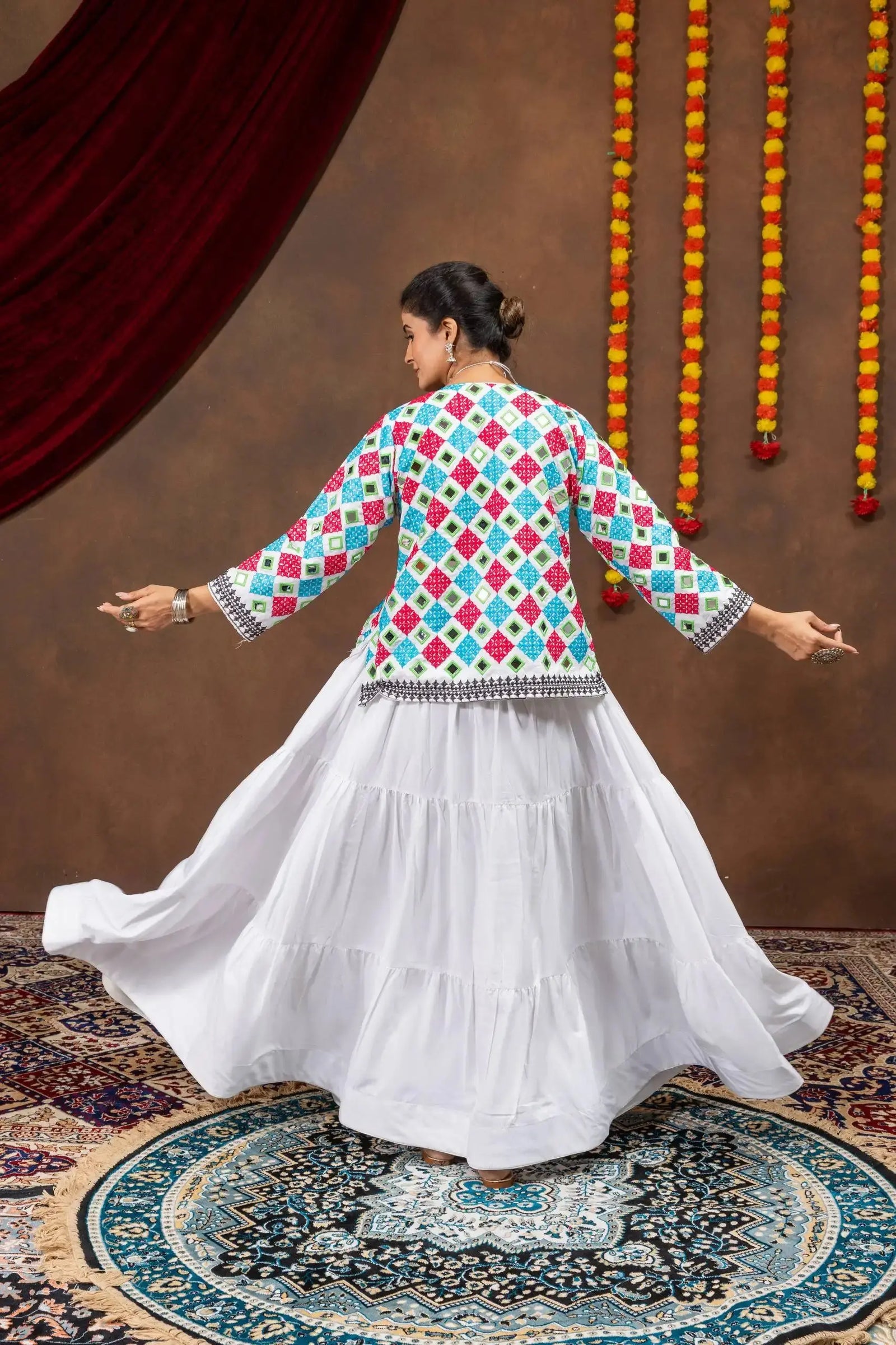 Back twirling view of white 6-meter tiered pure rayon lehenga with multicolor bandhej jacket
