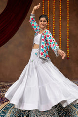 Dance pose in white embroidered mirror work lehenga with arm raised and full flair visible