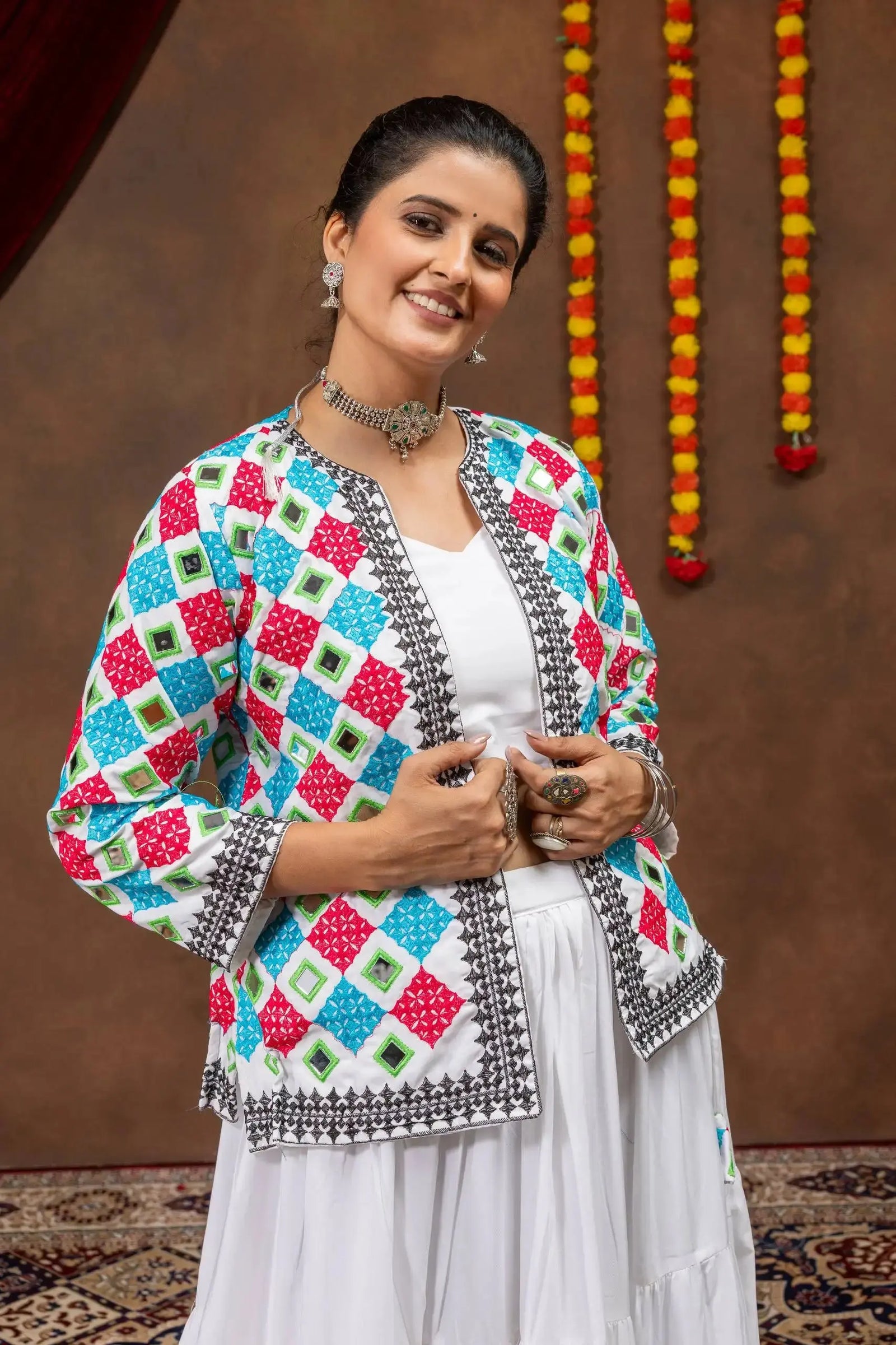 Portrait close-up of multicolor bandhej mirror-work koti over white choli, festive look