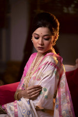 A woman models an opulent Off-White Soft Banarasi Silk Saree. The saree features multi-colored motifs and a wide Fuchsia Pink and gold Zari woven border and pallu with traditional patterns. She wears a contrasting pink long-sleeve blouse and heavy layered gold and pearl jewelry, posing in a luxurious, dramatically lit vintage setting.
Related
File name: modern-minimalist-architecture
Alt text: Sleek modern minimalist architecture with clean lines and large glass windows
